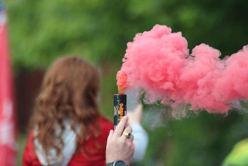 persona con bengala de humo de color rosa